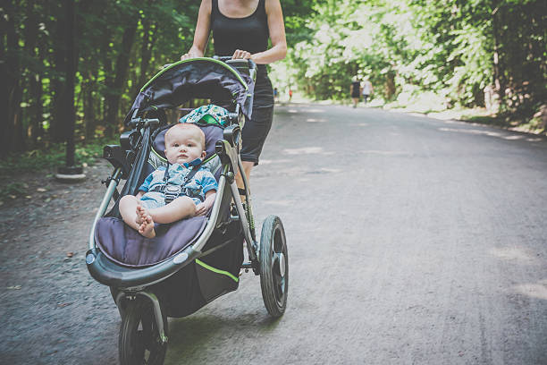 Mother Running and or Walking With a baby Stroller in a Park on a nice day of summer.