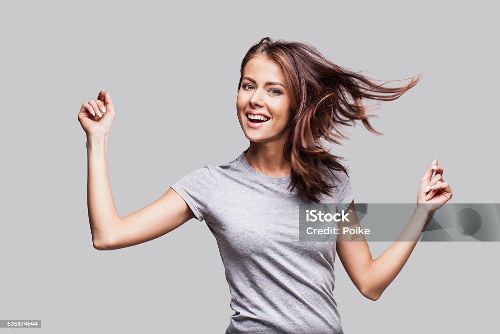 Beautiful emotional woman having fun Cute young girl with arms raised dancing and laughing and enjoying life Women Stock Photo