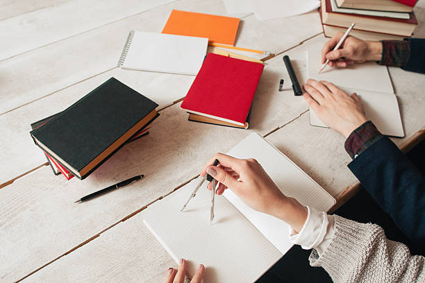istock Hands of pupils studying math at desk 635875408