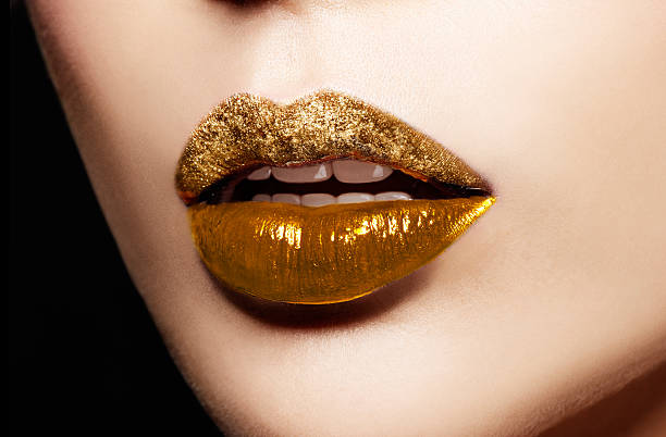Closeup of gold artistic lips. Makeup cosmetic image. stock photo