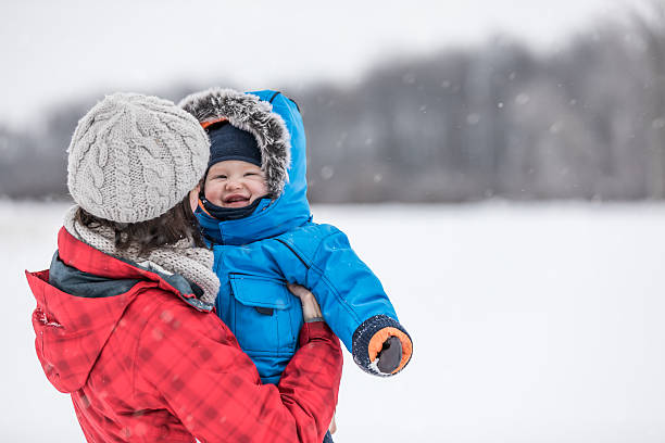 istock Mother and Son in Winter Forest Snowstorm 635876614