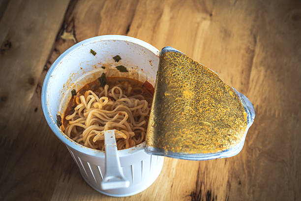 cooked instant cup noodle with ingredient on white background