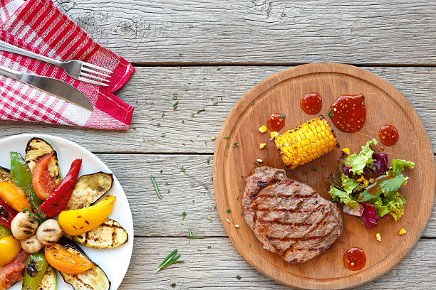 istock Grilled beef steak closeup on dark wooden table background 635876784