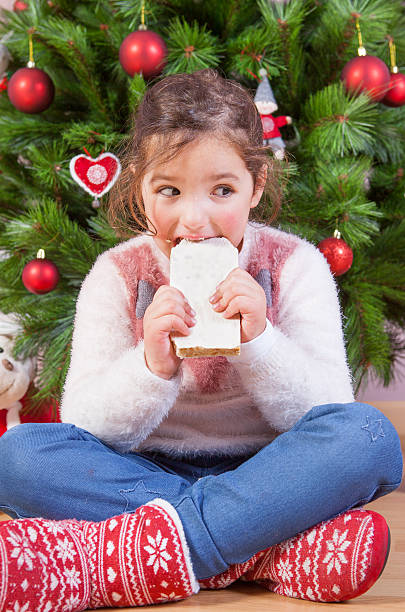 портрет счастливая девушка ест шоколад - torrone стоковые фото и изображения