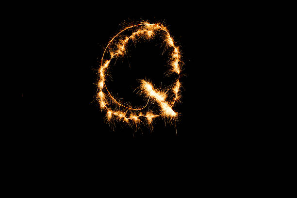 istock English alphabet from yellow sparkler on black background 635882430