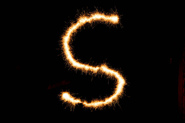 istock English alphabet from yellow sparkler on black background 635882578