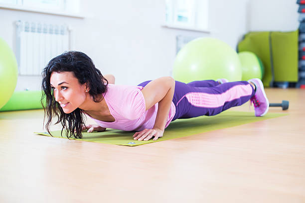 istock Fit woman doing plank exercise and push ups working on 635884220