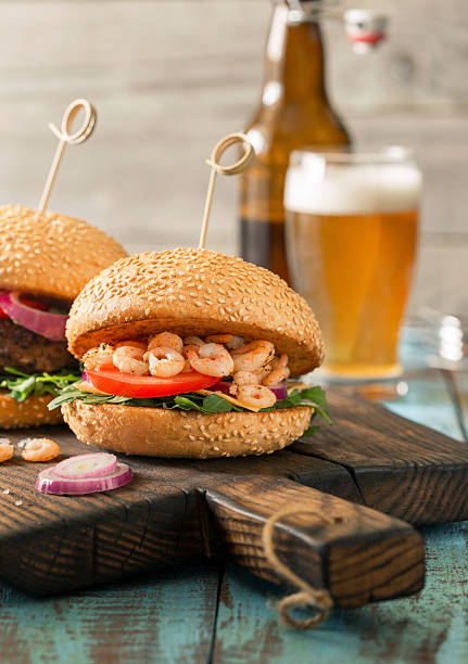 istock Close up burger with grilled prawns and glass light beer 635884802