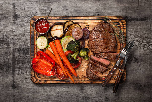istock Cooked grill dish with cut meat on wooden board 635884908