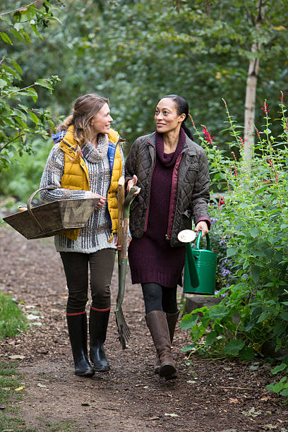 istock Two Friends Walking in Garden and Chatting 635887228
