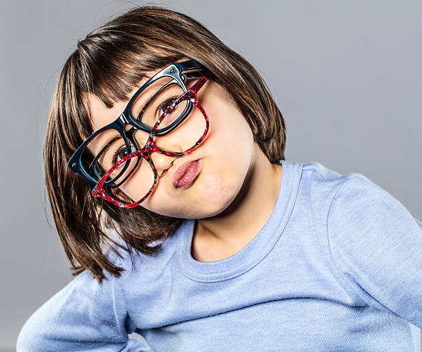 istock playful young child trying several eyeglasses pouting and hesitating 635888238