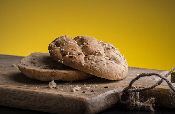 Bun with sesame seeds on a wooden board.