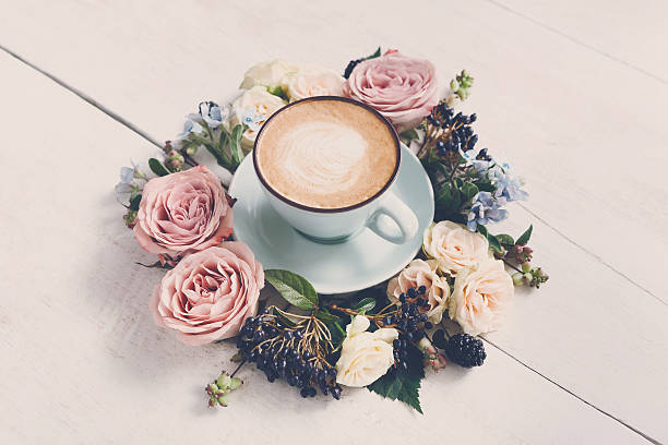 istock Cappuccino coffee and flowers composition on white wood 635891840