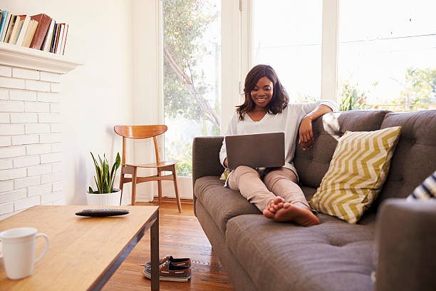 istock Woman Relaxing On Sofa At Home Using Laptop 635899476