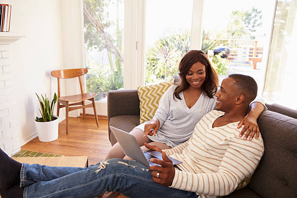 istock Couple Relaxing On Sofa At Home Using Laptop 635899478