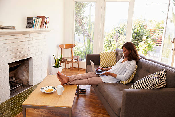 istock Woman Relaxing On Sofa At Home Using Laptop 635899482