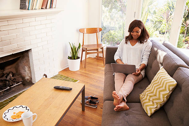 istock Woman Relaxing On Sofa At Home Using Laptop 635899484