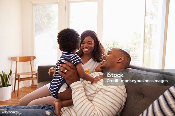 Parents And Son Playing Game On Sofa At Home Stock Photo - Download Image Now - Family, Sofa, African Ethnicity