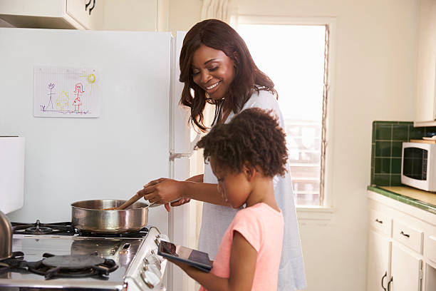 istock Mother And Daughter At Home Preparing Meal In Kitchen 635899626