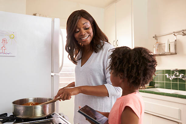 istock Mother And Daughter At Home Preparing Meal In Kitchen 635899630