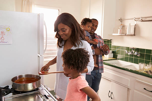 A waist up image of a caucasian mother and teenage daughter canning homegrown fruits and vegetables.