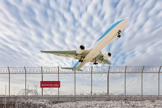Restricted area fence and Passenger airplane landing beautiful blue sky background