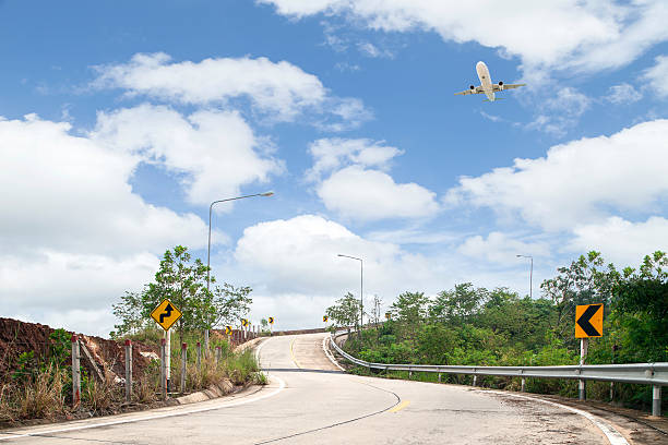istock road curve and Airplane flying with blue sky background, 635900802