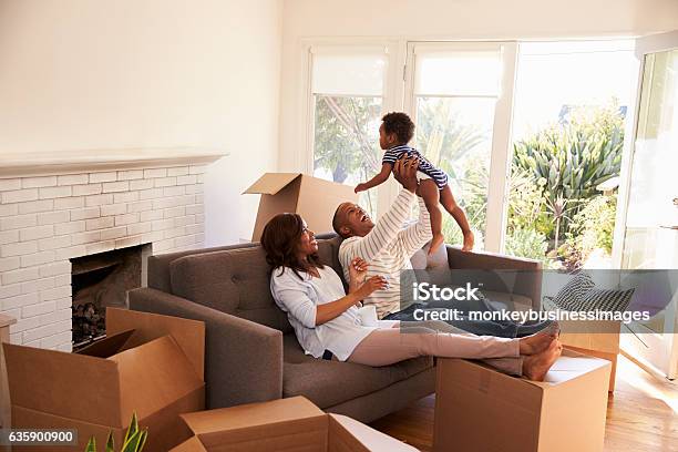 Parents Take A Break On Sofa With Son On Moving Day Stock Photo - Download Image Now