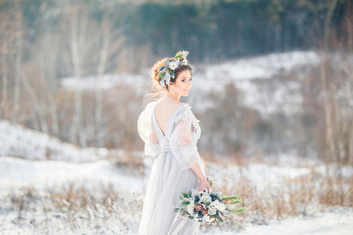The bride in the rays of the sun. Winter wedding.