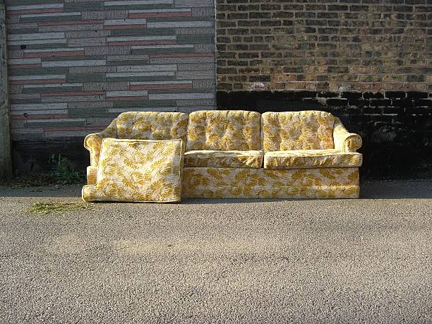 istock Abandoned old yellow couch in urban alley 635903682