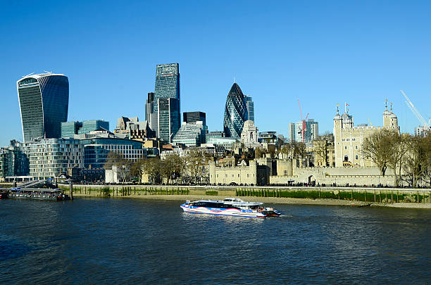 London, United Kingdom - January 15, 2016: Cruising ship on river Thames and Tower of London, sky garden building, leadenhall building aka cheese grater and The Gherkin aka 30 St.Mary street