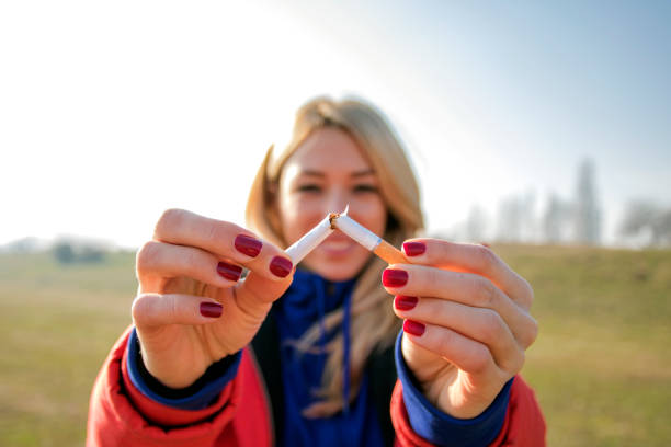 joven mujer feliz con rotura de cigarrillos. dejar de fumar concepto. - tobacco fotografías e imágenes de stock