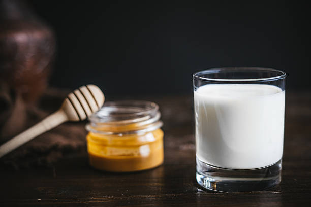 Glass jar with honey and milk stock photo