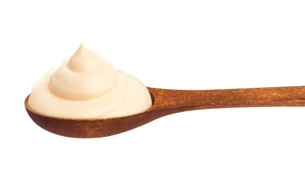 istock Sour cream in wooden spoon isolated on white 635909734