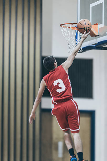 istock Male high school basketball player going up for a 635909936