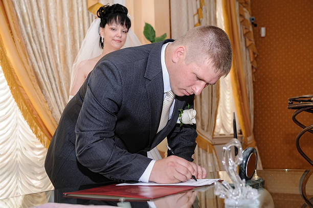 istock Pretty pair signing document of marriage 635910470