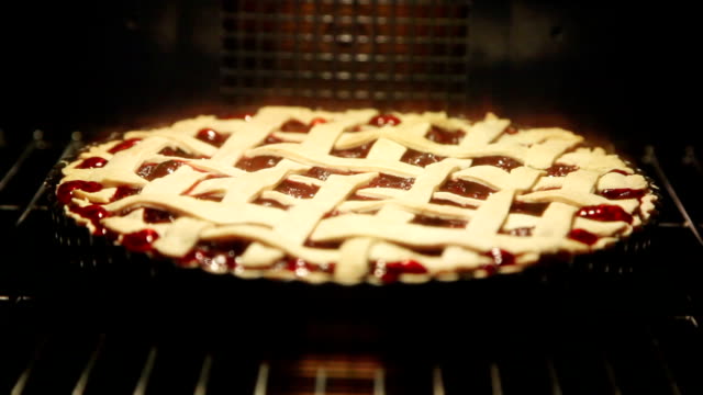 cherry pie cooking in oven