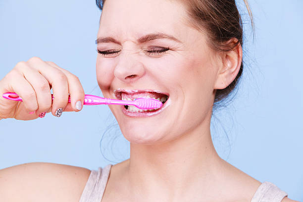 istock Woman brushing cleaning teeth 635914310