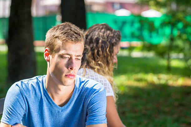 istock Sad young couple sitting on the bench 635917302