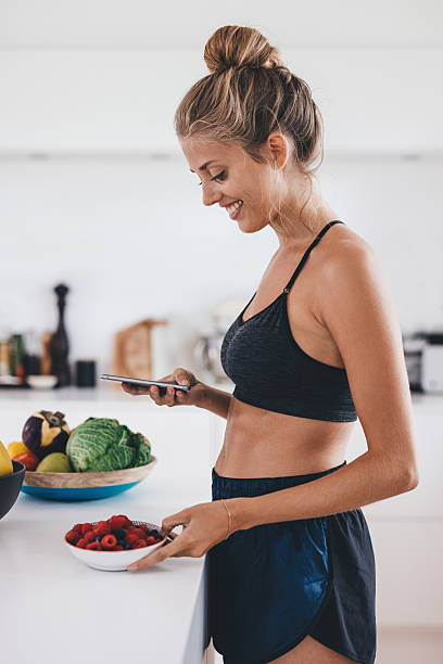 istock Beautiful woman in kitchen using mobile phone 635921592