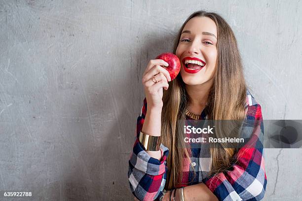 Woman With Apple On The Gray Background Stock Photo - Download Image Now - Apple - Fruit, Eating, Women
