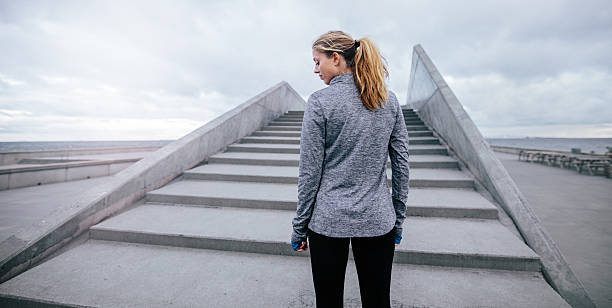 istock Fitness female standing by steps in morning 635923276