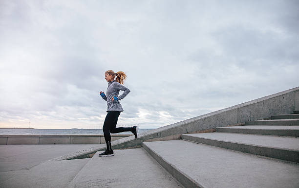 istock Healthy young woman running down the steps 635923896