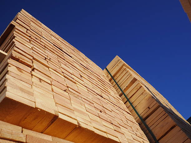 istock Stacks of planks against the deep blue sky 635931426