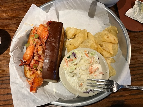 Lobster in the baked bread, fried potato chips, and cole slaw on the side.