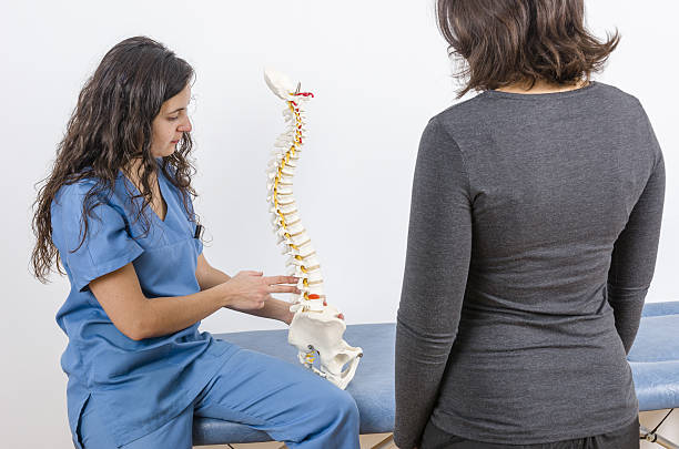 Doctor showing a skeleton to a patient. Back pain Doctor showing a skeleton to a patient. Back pain. medulla stock pictures, royalty-free photos & images