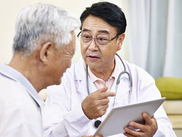 患者と話すアジアの医師 - chinese doctor ストックフォトと画像