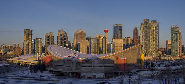 Calgary's skyline at sunrise Calgary, Canada - December 16, 2016: Panorama of Calgary's skyline at sunrise. The Saddledome is visible in the foreground and and modern office towers are visible in the background. scotiabank saddledome stock pictures, royalty-free photos & images