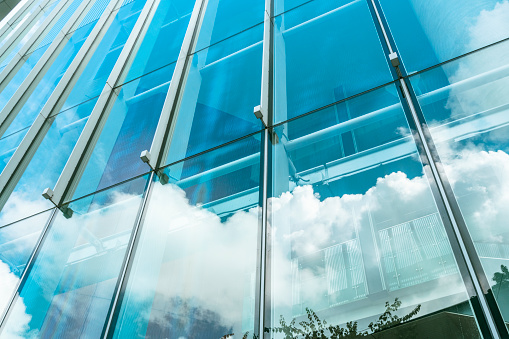 Closeup glass wall of office building with reflection of office buildings, background with copy space, full frame horizontal composition