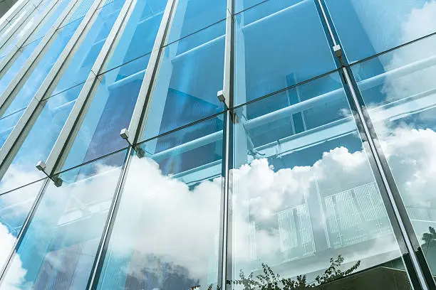 Photo of blue sky and clouds reflected at glass wall